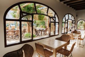 a room with a table and chairs and windows at La Bohemia del Rio Boutique Hotel - Adults Only in Santa Eularia des Riu