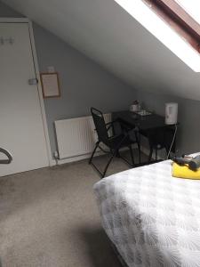 a attic room with a table and chairs and a bed at The Vale Apart Hotel in Hull