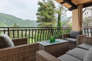 balcón con sillas, mesa y vistas a la montaña en Villa Gina Umbria Luxury Retreat en SantʼAnatolia di Narco