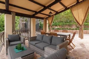 eine Terrasse mit einem Sofa, Stühlen und einem Tisch in der Unterkunft Villa Gina Umbria Luxury Retreat in SantʼAnatolia di Narco