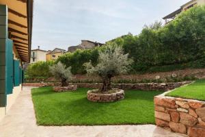 un jardín con 2 árboles en una pared de piedra en Villa Gina Umbria Luxury Retreat, en SantʼAnatolia di Narco