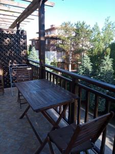 Private holiday flat by seaside - Santa Marina- Sozopol في سوزوبول: طاولة خشبية وكرسي على شرفة