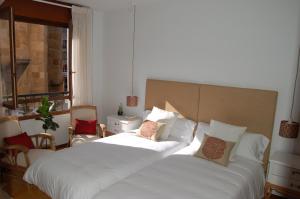 a bedroom with a large white bed and a window at La Casa de Zamora in Zamora