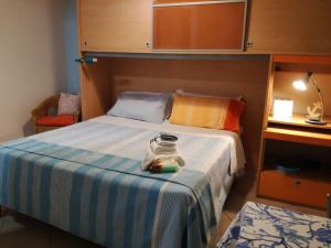a bedroom with a bed with a blue and white striped blanket at Goccia Azzurra in Silvi Marina