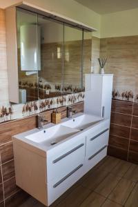 a bathroom with two sinks and a large mirror at Forest Luxury Apartman in Dorogháza