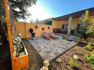 a patio in the backyard of a house at Vámos Apartman in Bük