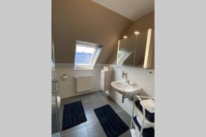 a bathroom with a sink and a toilet and a mirror at Ferienwohnung Zwischen Eider u. Elbe in Eddelak