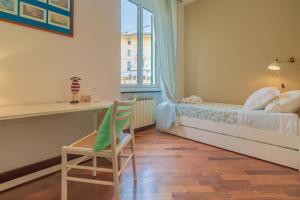 1 dormitorio con cama, escritorio y silla en Casa Claudia, en Rapallo