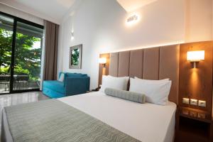 a bedroom with a large bed and a blue chair at 4- you Family in Metamorfosi