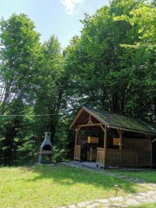 a small gazebo with a bell in the grass at Cabana Anita in Sovata +6 photos
