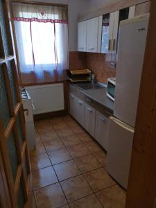 eine Küche mit einem weißen Kühlschrank und Fliesenboden in der Unterkunft Cabana Anita in Sovata
