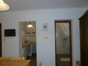 a kitchen with a dining table and a bathroom at Ninszianna Apartman in Hegyhátszentjakab