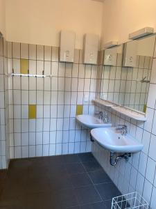 een badkamer met 2 wastafels en 2 spiegels bij Grüne Wiek Wabenhausherberge Beckerwitz in Gramkow
