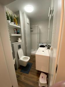 mała łazienka z toaletą i umywalką w obiekcie MIĘDZYZDROJE,BALTICUS PROMENADA GWIAZD 14, Apartament z odrębnym salonem i sypialnią z Widokiem na morze w mieście Międzyzdroje +37 zdjęć