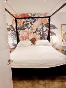 1 dormitorio con 1 cama con pared de flores en Quirky Seaside Family Cottage walk to the waves! en Brighton & Hove