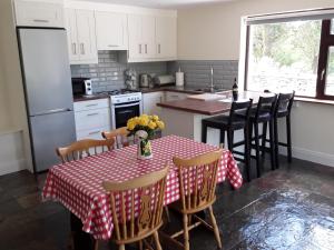 cocina con mesa y mantel rojo y blanco en Mary’s Cottage, en Sneem