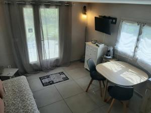 een slaapkamer met een bed, een tafel en een bureau bij Gîte de charme in Arles