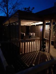 - une terrasse en bois la nuit avec une maison dans l'établissement Ardgowan Cottage, à Brodick