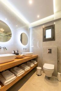 a bathroom with a sink and a toilet and a mirror at 3 DOORS VILLAS in Iraklitsa +116 photos