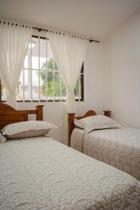 1 dormitorio con 2 camas y ventana en ESPECTACULAR CASA, AMPLIA E ILUMINADA, DOTADA, en Anapoima