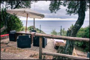 uma mesa com um guarda-chuva ao lado de uma cerca em Corner of Paradise near Cinque Terre em Framura