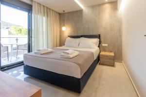 a bedroom with a large bed with towels on it at 3 DOORS VILLAS in Iraklitsa