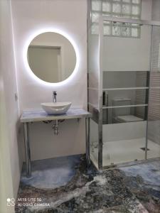 La salle de bains est pourvue d'un lavabo et d'un miroir. dans l'établissement VILLA MARIA I CASA MONICA Y GEORGE PLAYA EL PUNTAL CASA ADOSADA Villaviciosa, à Villaviciosa