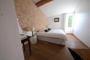 a bedroom with a bed and a brick wall at Bastide le Petit Clos - les 2 Gîtes in Perpignan +58 photos