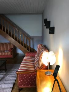 a living room with a couch and a table with a lamp at Saint Vincent in Bué