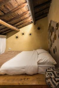 - une chambre avec un lit doté de draps et d'oreillers blancs dans l'établissement Opera Suites - Le mille e una notte, à Calcata