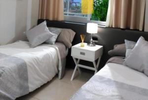 - une chambre avec deux lits et une table de chevet avec une lampe dans l'établissement Marina D’Or. Miramar. Estrenar., à Oropesa del Mar