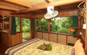 a bedroom with a bed with a flower on it at Casa Rio Blanco Eco Friendly B&B in Guápiles