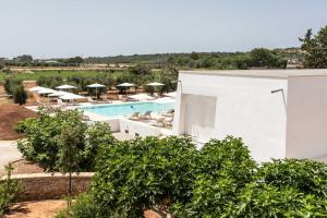 ein Bild eines Resorts mit Pool und Bäumen in der Unterkunft Palummare - Agri Hotel Relais in Torre San Giovanni Ugento