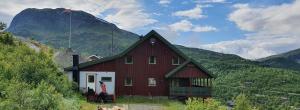 una casa roja con una montaña en el fondo en Røisheim en Tyinkrysset