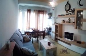 sala de estar con sofá azul y mesa en Las Golondrinas Zaragoza habitación para una persona, en Zaragoza