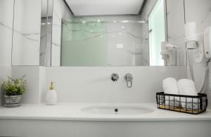 a white bathroom with a sink and a mirror at 4- you Family in Metamorfosi