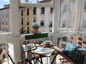 a balcony with a table and chairs and a window at Pension Boutique Doña Urraca in Burgos
