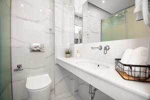 a white bathroom with a toilet and a sink at 4- you Family in Metamorfosi +37 photos