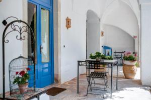 una stanza con una porta blu, sedie e piante di Masseria La Macchiola & Corti del Mito a Spongano