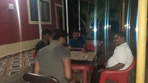 Eine Gruppe von Männern, die an einem Tisch sitzen und ein Videospiel spielen in der Unterkunft Sagar sandhya home stay in Dapoli