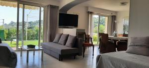 a living room with a couch and a tv at Maison Margot in Vallauris