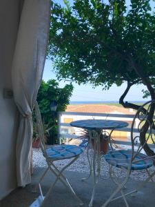 ポザーダにあるSu Soleのテーブルと椅子、海の景色を望むバルコニー
