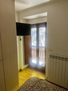 Residence Cavallino Bianco في تيرمينيلو: غرفة نوم مع باب يؤدي إلى النافذة