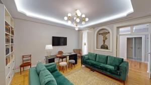 a living room with a green couch and a table at Casa dos Ofícios Hotel in Tomar