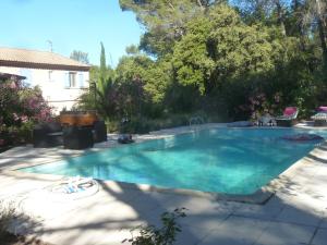 a swimming pool with blue water in a yard at la grande villa des Oliviers in Draguignan