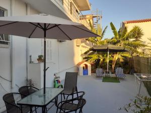 a patio with a table and chairs and an umbrella at Chania Dream Home in Chania