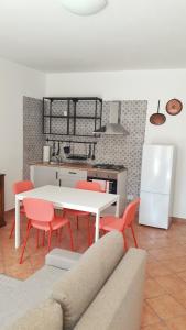 uma sala de estar com uma mesa branca e cadeiras vermelhas em MAX and SUN parking privato nel prezzo em Sanremo