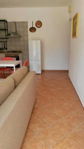 a living room with a couch and a refrigerator at MAX and SUN parking privato nel prezzo in Sanremo