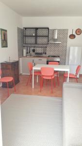 a kitchen with red chairs and a white table at MAX and SUN parking privato nel prezzo in Sanremo