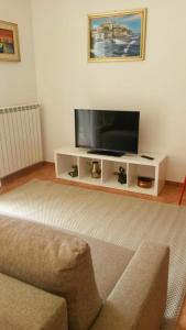 a living room with a television on a white entertainment center at MAX and SUN parking privato nel prezzo in Sanremo